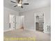 Bright main bedroom area featuring a fan, multiple windows, carpet, and walk-in closet at 188 Buckaroo Dr, Louisburg, NC 27549