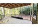 Screened-in porch with a wooden floor overlooking a lush green forest beyond the backyard at 188 Buckaroo Dr, Louisburg, NC 27549