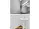 Contemporary powder room with a pedestal sink, stylish mirror, and elegant wall paneling at 188 Buckaroo Dr, Louisburg, NC 27549