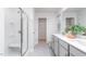 Bright bathroom boasts double vanity with gray cabinets and shower with a glass door at 1901 Hinesley Dr, Durham, NC 27703