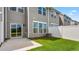 Private backyard featuring a concrete patio, grassy area, and white fence; perfect for outdoor relaxation and entertaining at 1903 Hinesley Dr, Durham, NC 27703