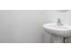 A simple half bath with a pedestal sink and chrome faucet set against a light neutral wall at 1903 Hinesley Dr, Durham, NC 27703