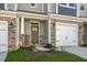 Close up of a townhouse front door, showing stone detail and a one car garage at 1905 Hinesley Dr, Durham, NC 27703