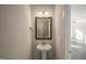 A small powder room with a pedestal sink, mirror, and sconce lighting at 1905 Hinesley Dr, Durham, NC 27703