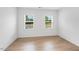 Well-lit bedroom featuring hardwood floors and two large windows at 2021 Clydner Dr, Apex, NC 27523