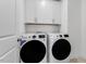Laundry room with white cabinets above washer and dryer at 2021 Clydner Dr, Apex, NC 27523