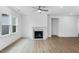 Bright living room with hardwood floors, a fireplace, and large windows for natural light at 2021 Clydner Dr, Apex, NC 27523