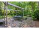 Lush backyard with a brick patio, pergola, dining set, green lawn, and mature trees at 206 N State St, Raleigh, NC 27601