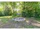 Backyard fire pit surrounded by lush green trees and a small storage shed at 206 N State St, Raleigh, NC 27601