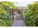 View of the home showcasing its inviting front porch with beautiful flowering vines and lush greenery at 206 N State St, Raleigh, NC 27601