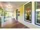 Covered front porch with painted wood floors, yellow siding, green trim and hanging basket at 206 N State St, Raleigh, NC 27601