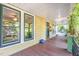 Inviting front porch with wood flooring, yellow siding, large windows, and green trim at 206 N State St, Raleigh, NC 27601