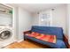 This room features hardwood flooring, 1 window, a futon bed and a laundry closet with modern washer at 206 N State St, Raleigh, NC 27601