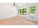 Bright bedroom features hardwood floors, a modern ceiling fan, and a large window with natural light at 2205 Tampa Ave, Durham, NC 27705