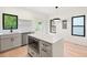 Modern kitchen with gray cabinets, white island, hardwood floors, and ample natural light at 2205 Tampa Ave, Durham, NC 27705