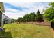Expansive backyard with green grass, a black fence, mature trees, and a playground, perfect for outdoor activities at 2601 Brookstone Ridge, Raleigh, NC 27613