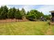 Spacious backyard featuring lush green lawn, privacy fence, mature trees, and a playset at 2601 Brookstone Ridge, Raleigh, NC 27613