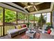 Relaxing screened-in porch with wooden flooring, ceiling fan, and outdoor seating overlooking the lush green yard at 2601 Brookstone Ridge, Raleigh, NC 27613