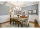 Gray dining room featuring a modern chandelier, wainscoting, and stylish decor at 2601 Brookstone Ridge, Raleigh, NC 27613