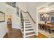 Elegant staircase leading to a dining room with coffered ceilings and wainscoting at 2601 Brookstone Ridge, Raleigh, NC 27613