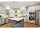 Modern kitchen with white cabinets, stainless appliances, marble countertops and hardwood floors at 2601 Brookstone Ridge, Raleigh, NC 27613