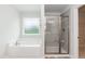 Bathroom featuring a soaking tub, glass shower door, and frosted window at 283 Hopewell Br Ct, Smithfield, NC 27577