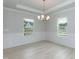 Bright dining room with hardwood floors, wainscotting, modern chandelier, and natural light from two large windows at 283 Hopewell Br Ct, Smithfield, NC 27577