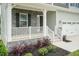 Charming front porch featuring stone accents, white railings, and lush landscaping at 283 Hopewell Br Ct, Smithfield, NC 27577