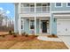 Close up view of a two-story home's front door with a black door and white columns at 3008 Dog Rose Dr # 307, Durham, NC 27703