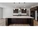 Spacious kitchen with a center island, dark cabinets, and sleek pendant lighting at 3008 Dog Rose Dr # 307, Durham, NC 27703