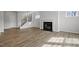 Open concept living room with fireplace and staircase with dark iron spindles at 3008 Dog Rose Dr # 307, Durham, NC 27703