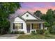 Charming home featuring a gray door, black shutters, and lush lawn at sunset at 303 Godwin St, Selma, NC 27576