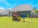 Spacious backyard with green grass and a wooden playset, perfect for outdoor fun and relaxation at 3413 S Beaver Ln, Raleigh, NC 27604