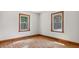 Bedroom with wood floors featuring two bright windows at 3899 Warrenton Rd, Henderson, NC 27537