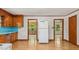 Spacious kitchen with wood cabinets, adjacent rooms, and a full-size white refrigerator at 3899 Warrenton Rd, Henderson, NC 27537