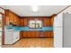 A kitchen featuring knotty pine cabinets, blue countertops, and a white refrigerator at 3899 Warrenton Rd, Henderson, NC 27537