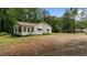 View of the rear exterior with a view of the yard and mature trees offering space and privacy at 3899 Warrenton Rd, Henderson, NC 27537