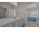 Bathroom featuring a white sink and mirror with views to a secondary bedroom at 49 Salt Cedar Ln, Chapel Hill, NC 27516