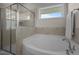 Bathroom featuring a tub, glass shower with tile surround and a window at 49 Salt Cedar Ln, Chapel Hill, NC 27516