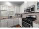 Bright kitchen features stainless steel appliances, granite countertops, tiled backsplash and hardwood flooring at 49 Salt Cedar Ln, Chapel Hill, NC 27516