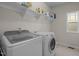 Laundry room with a washer, dryer, and storage shelf at 49 Salt Cedar Ln, Chapel Hill, NC 27516