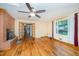 Spacious living room features hardwood floors, brick fireplace, ceiling fan and natural light at 515 Poplar Dr, Raleigh, NC 27603