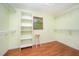 Spacious walk-in closet with custom shelving, window, and wood-look laminate flooring at 515 Poplar Dr, Raleigh, NC 27603