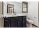 Modern bathroom with navy vanity, white countertops, a framed mirror, and contemporary fixtures at 522 Lochness Ln, Cary, NC 27511