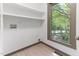 Bright laundry room with wood-look flooring, shelving, utility connections, and a large window at 522 Lochness Ln, Cary, NC 27511