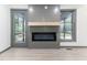 Living room with gray accent wall with electric fireplace, light wood mantle, and hardwood flooring at 522 Lochness Ln, Cary, NC 27511