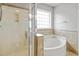 Bright bathroom with a glass shower and soaking tub with tile surround and a window at 524 Woodson Dr, Clayton, NC 27527
