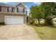 Lovely townhouse featuring a two-car garage, manicured lawn, and healthy landscaping at 524 Woodson Dr, Clayton, NC 27527