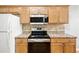 Well-equipped kitchen features stainless steel appliances and ample wooden cabinetry for storage at 524 Woodson Dr, Clayton, NC 27527
