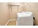Well-lit laundry room with washer, dryer, and overhead shelving for storage at 524 Woodson Dr, Clayton, NC 27527
